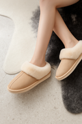 Woman wearing beige fox fur cotton slippers indoors