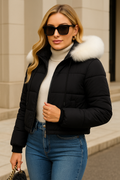 Black hooded puffer jacket with white fur trim worn for a winter streetwear look