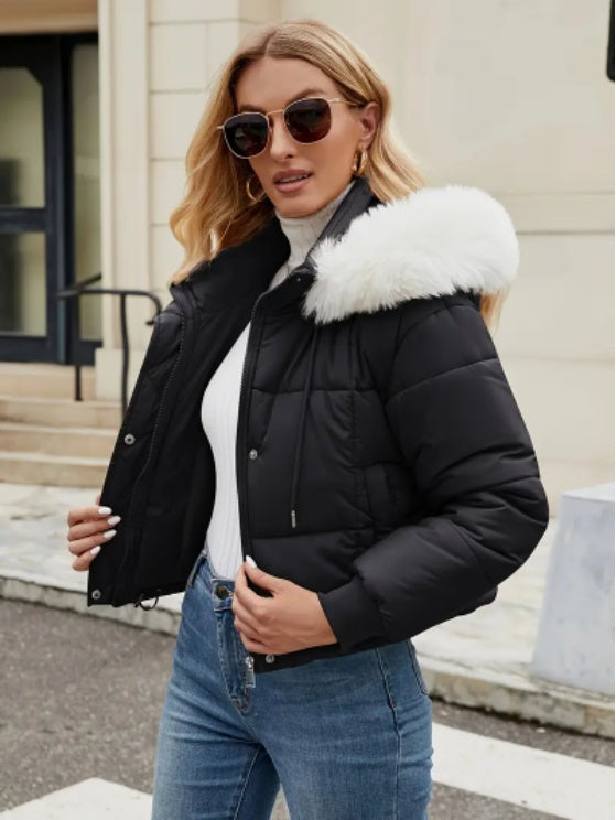 Model styled in a chic black winter jacket with soft fur around the hood.